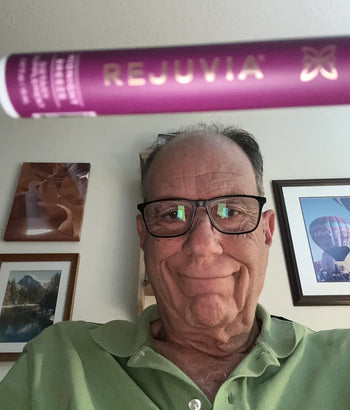 rejuvia customer holding up sleep spray to the camera