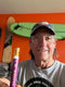 Man holding a purple pen with a Rejuvia logo against an orange wall with skateboards.