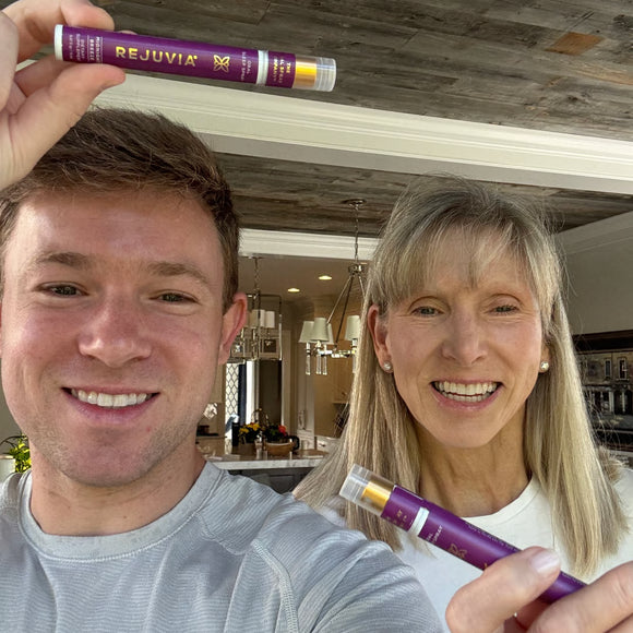 Two people holding purple 'REJUVIA' tubes in a kitchen setting.